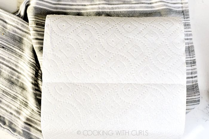 A paper towel laying on top of the cheesecake. 