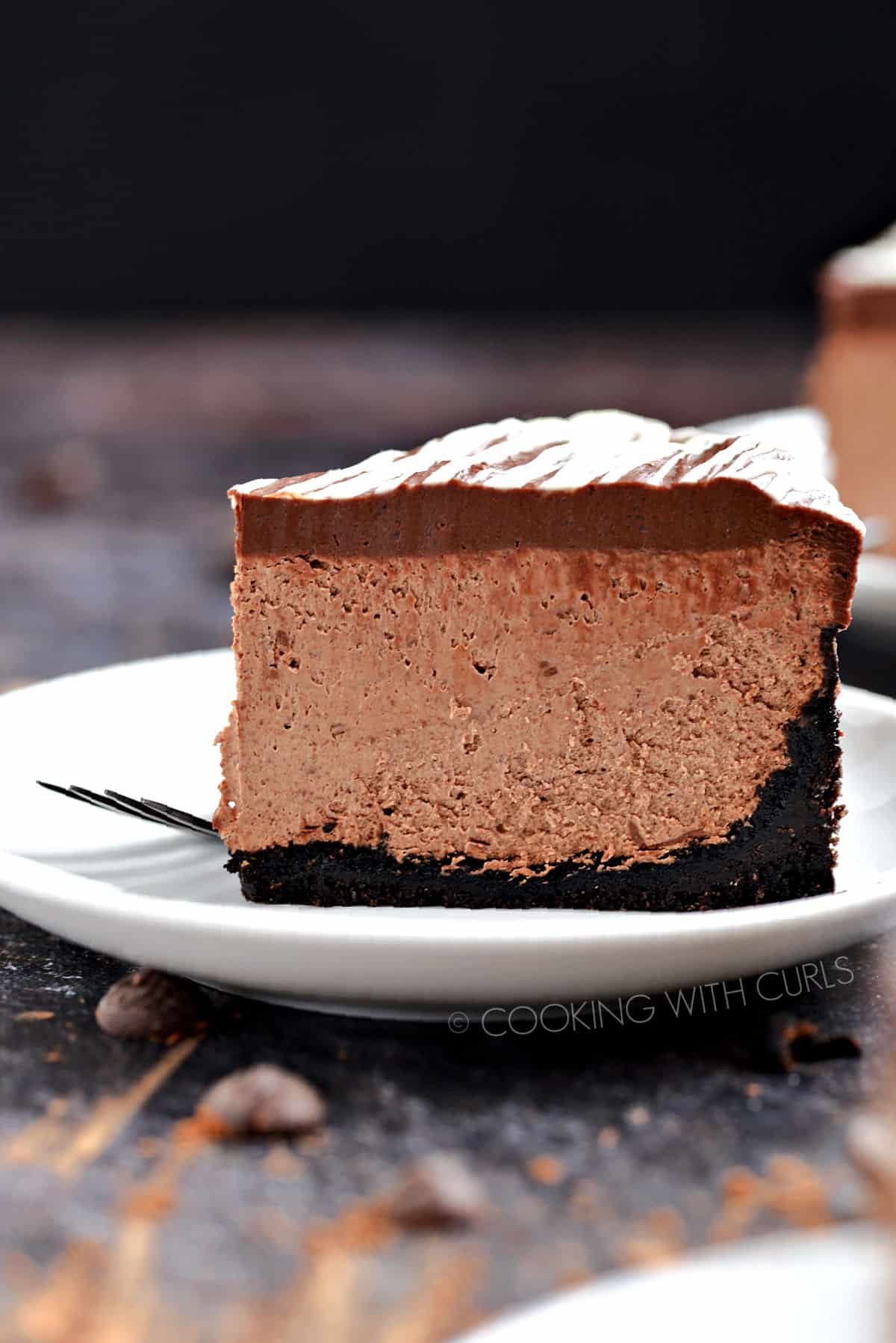A slice of Instant Pot Death by Chocolate Cheesecake on a white plate.