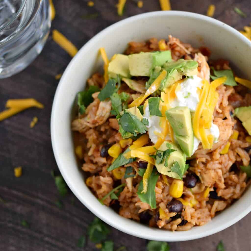 looking down on a bowl of Chicken Taco Bowls topped with cheese, avocado and sour cream