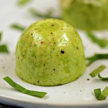 Two green spinach and cheese egg bites on a plate.