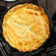 Looking down on a Skillet Chicken Pot Pie recipe with plates and forks in the background.