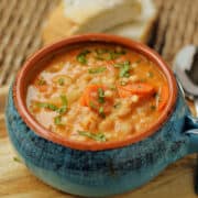 A bowl of beans soup with carrots and potatoes.