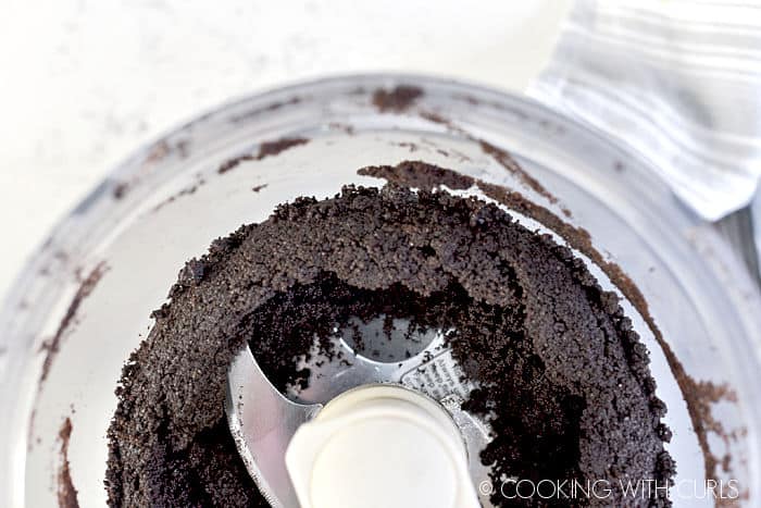OREO cookies mixed with butter in a food processor. 