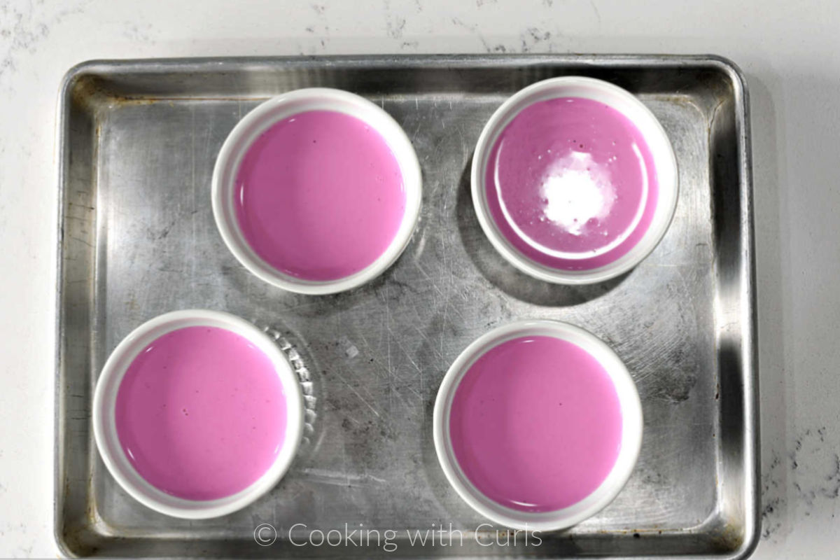 Panna Cotta in four small ramekins on a small baking sheet. 