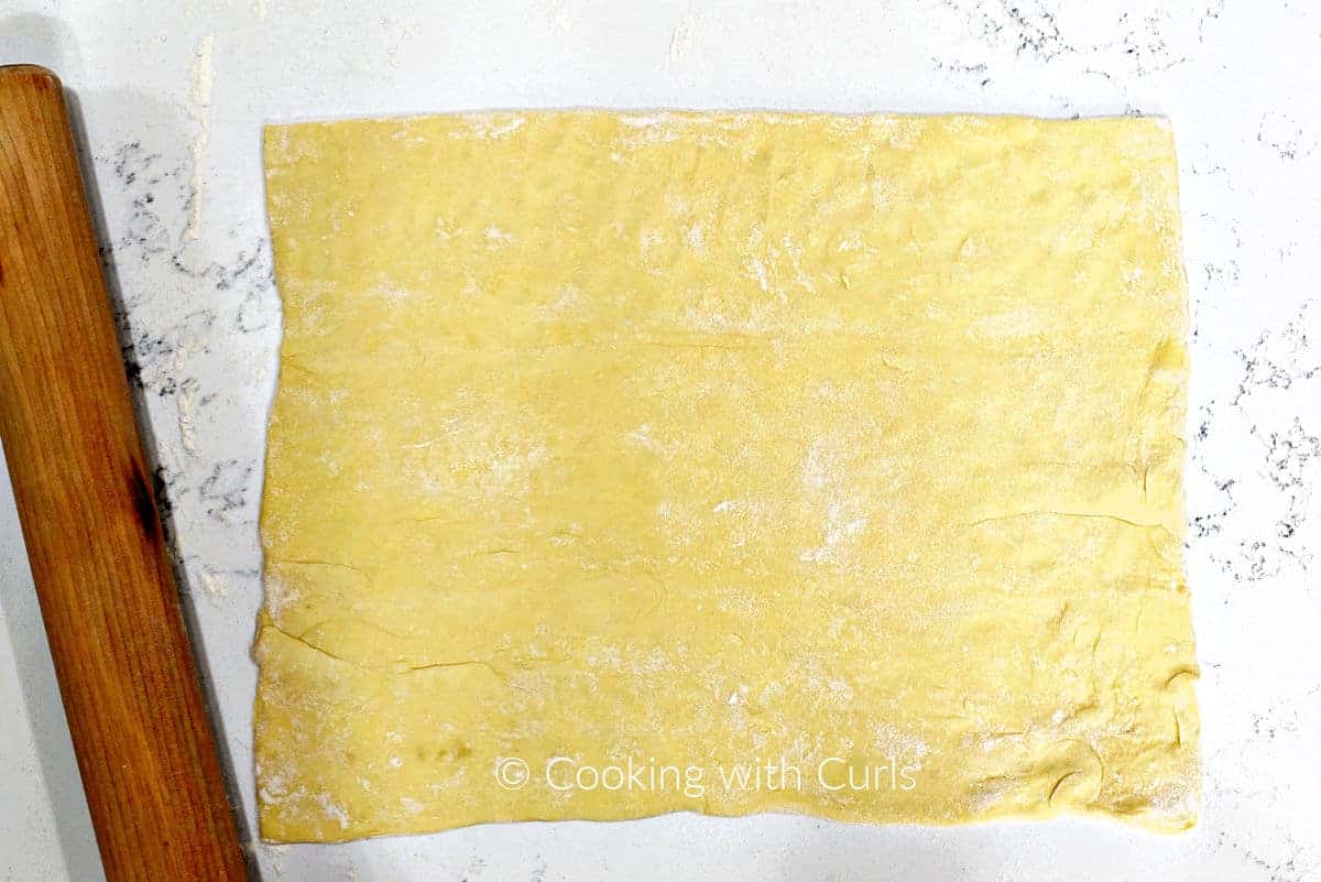 Puff pastry dough rolled out on the counter. 