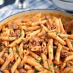 Sloppy Joe Pasta Skillet on a blue and white napkin with empty white bowls in the background.