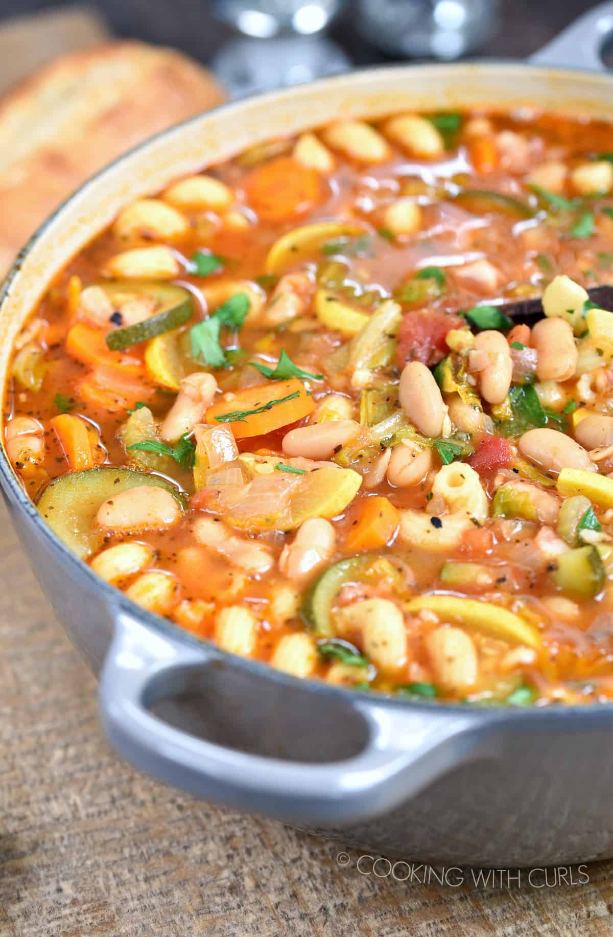 a big pot of Minestrone Soup with a baguette in the left corner.